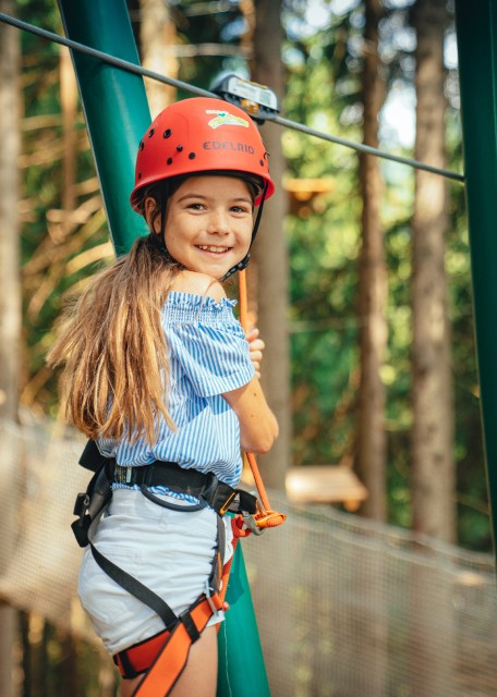 Mädchen klettert am Wald-Hochseilgarten
