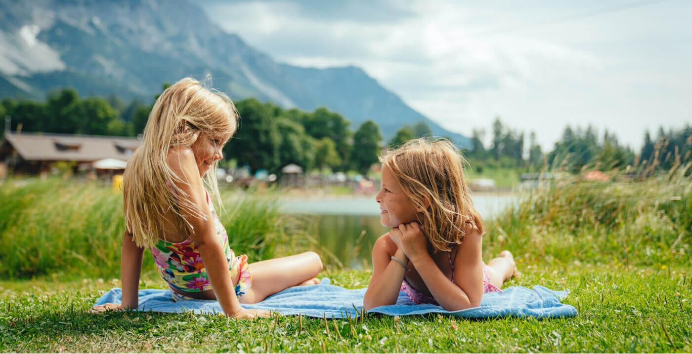 Zwei Mädchen sonnen am Badesee in Ramsau am Dachstein