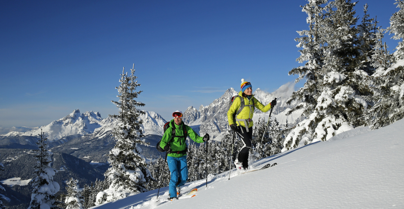 Zwei Tourenski-Geher genießen beim Aufstieg den Ausblick auf die Bergwelt am Rittisberg