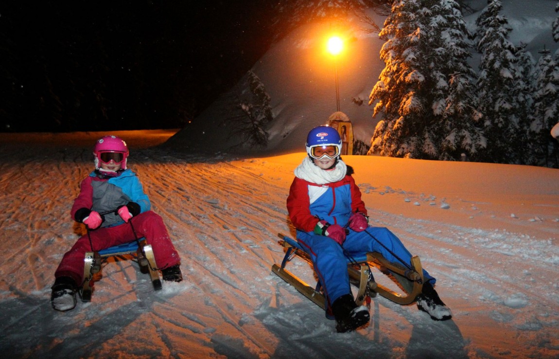 Zwei Kinder beim Nachtrodeln am Erlebnis Rittisberg